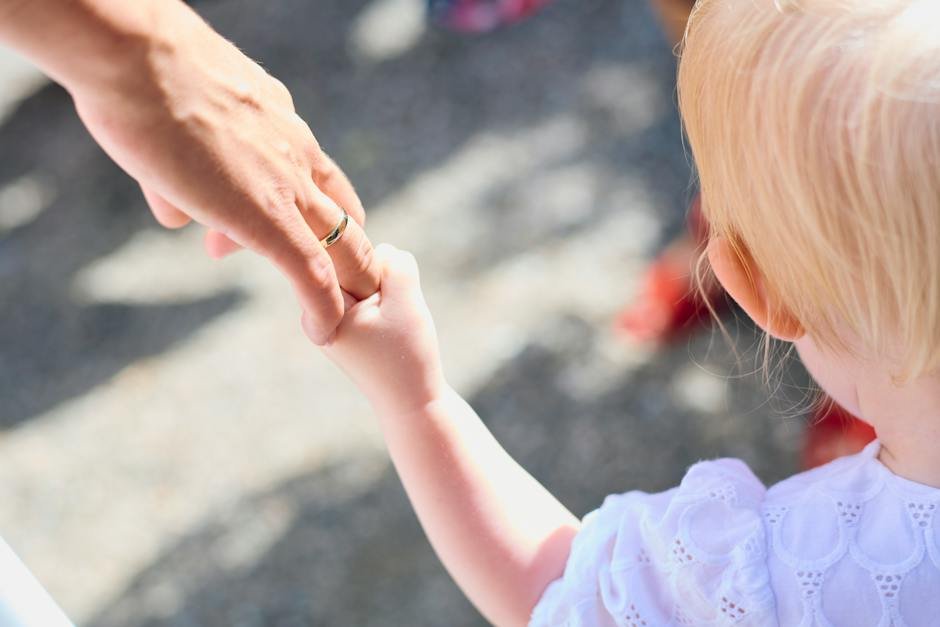 Image of a child with autism holding hands with their parent, symbolizing the need for a comprehensive response plan to ensure their safety.