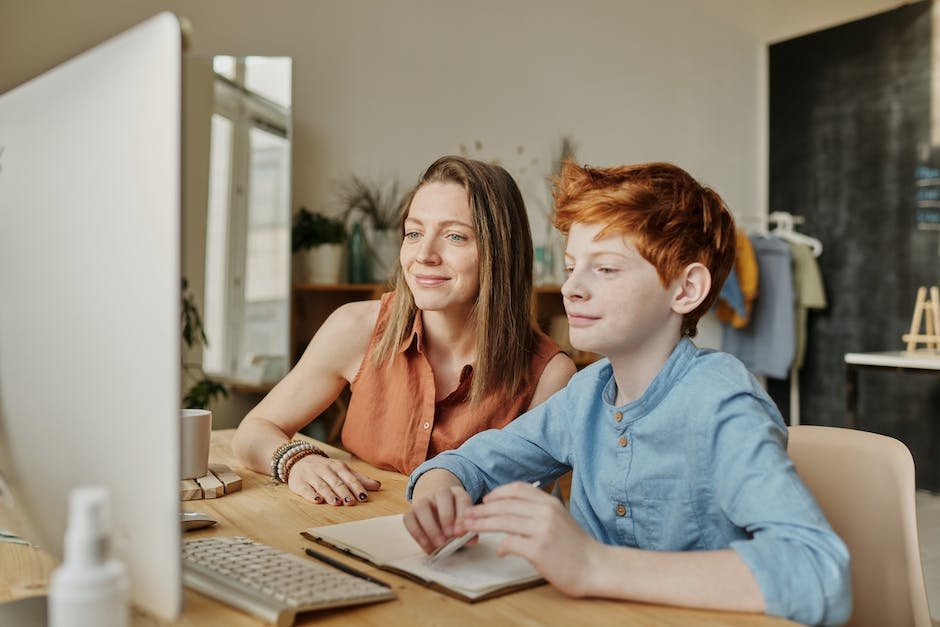 Image depicting a child engaged in online learning with a parent in a supportive environment