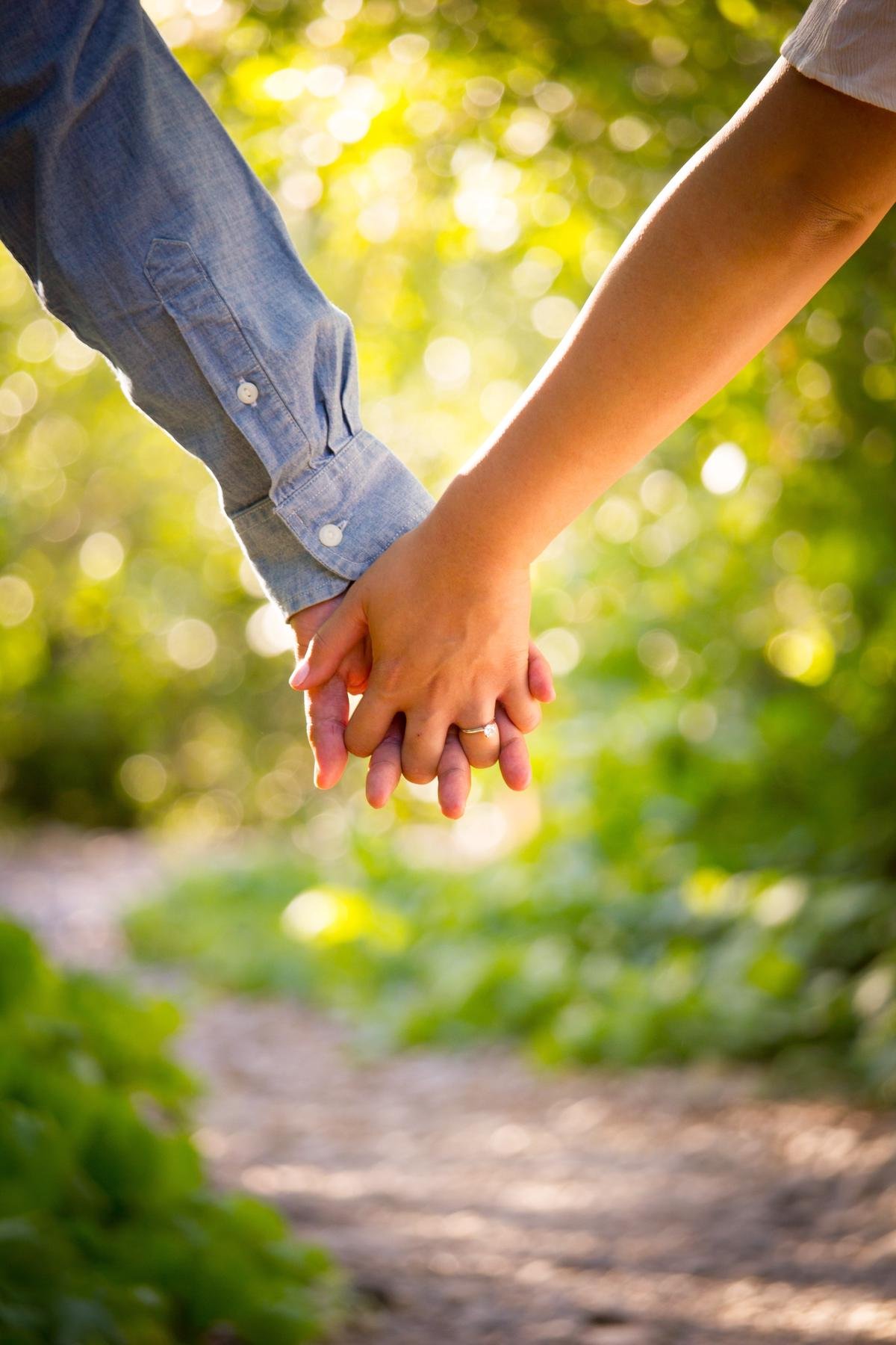 Image of a person holding hands with a child with Autism, symbolizing the love and support in the caregiver's journey