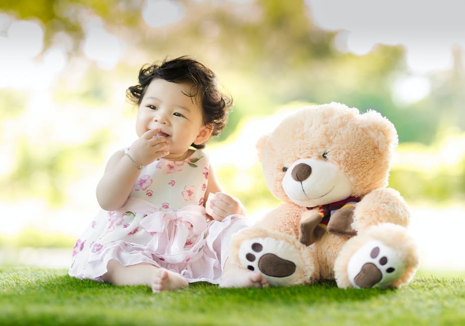 Image of a smiling child wearing a mask and holding a teddy bear, representing child health and wellbeing