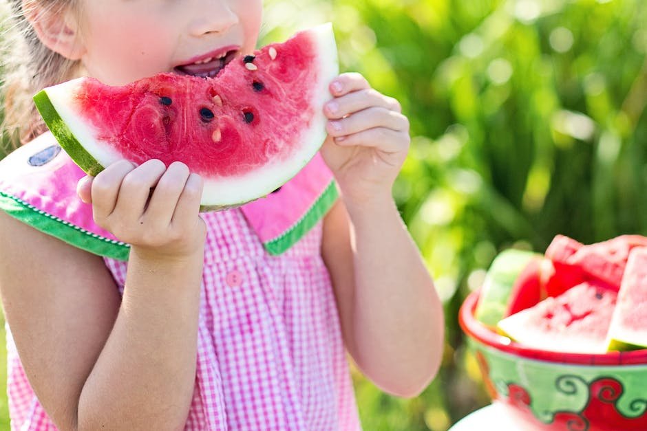 An image of a child happily eating healthy fruits and vegetables, showcasing the importance of nutrition in managing autism symptoms.