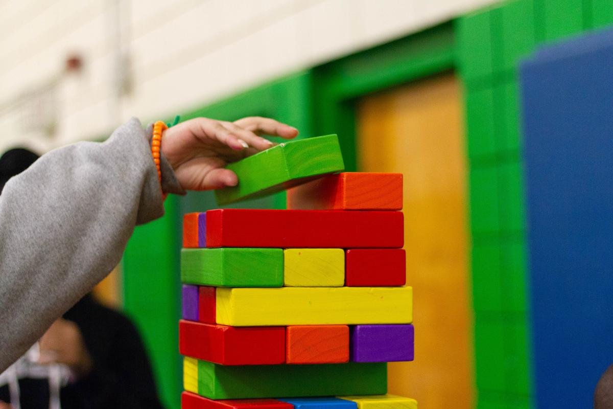 Image of a child engaged in repetitive play, using stacking blocks, sorting objects, and threading