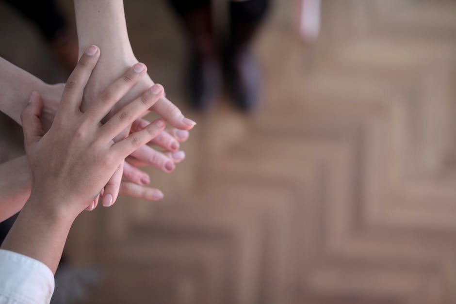 Image showing a diverse group of people holding hands forming a support circle around a child with autism.