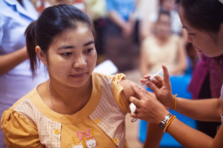 An image showing a mother and child receiving a vaccination from a healthcare professional