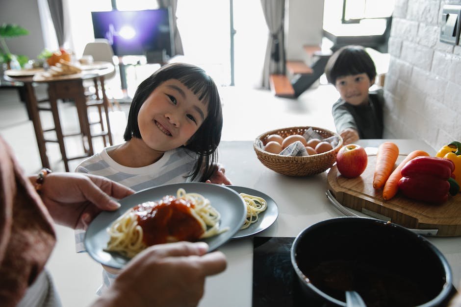Image depicting a parent helping a child with autism eat a nutritious meal