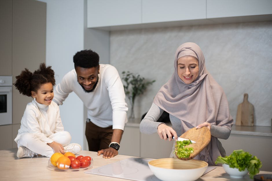 A diverse family sitting together at a table, preparing and enjoying a healthy meal.